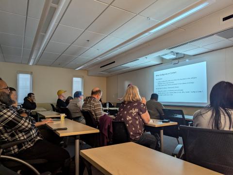 People in a class room watching a speaker with slides