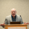 a picture of Matthew Saunders at a podium speaking.