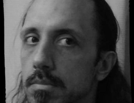 Head shot of Chris Thompson in black and white, sporting a mustache with soul patch.